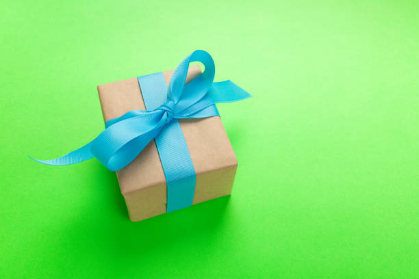 istock gift wrapped and decorated with blue bow on green background with copy space. Flat lay, top view 1063736136