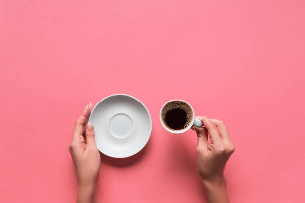 bras femmes tenir la tasse de café sur fond rose. vue de dessus avec espace de cope - high angle view people people in a row directly above photos et images de collection