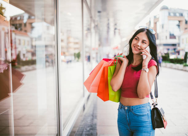istock Woman with shopping bags using phone downtown 1063738196