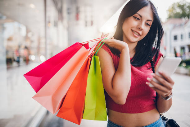 istock Woman with shopping bags using phone downtown 1063738414