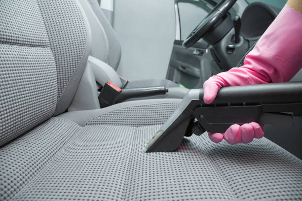 istock Cleaner hand in protective glove cleaning textile front passenger seat with professionally extraction method. Regular cleanup. Care about auto interior. Commercial cleaning company. Low angle view. 1063742862