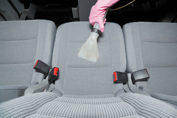 istock Cleaner hand in protective glove cleaning gray textile back passenger seat with professionally extraction method. Regular cleanup. Care about auto interior. Commercial cleaning company. Top view. 1063744574