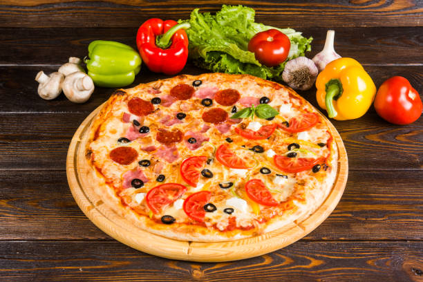 istock 2 kinds of pizza in one - salami, tomatoes, ham. Creative author's pizza. 1063750976