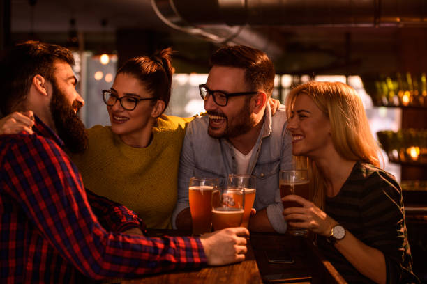 friends in pub drinking beer having fun - irish culture beer drinking pub imagens e fotografias de stock