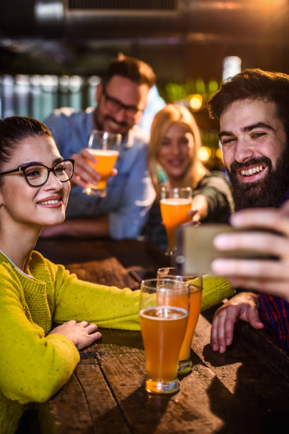 friends in pub drinking beer having fun - irish culture beer drinking pub imagens e fotografias de stock