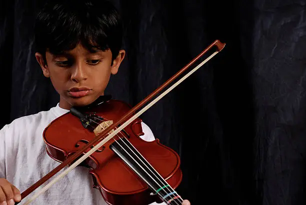 Young boy playing the violin (with copy space).