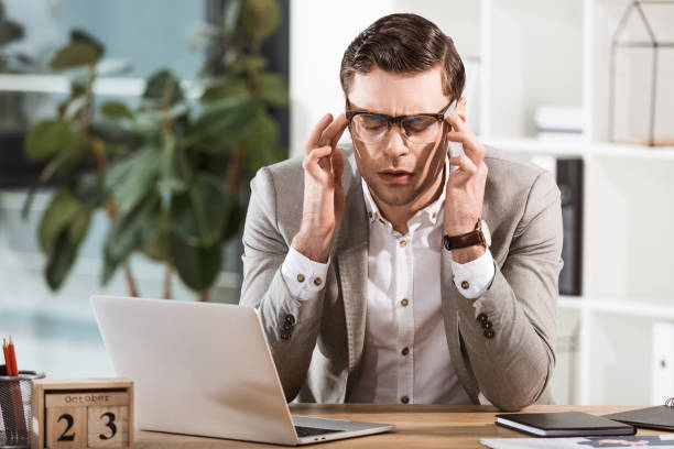 istock overworked businessman suffering from headache while sitting at workplace in office 1063755142