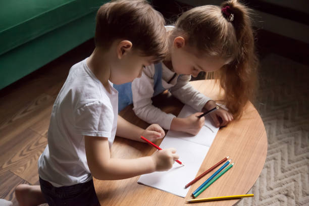 istock Brother and sister drawing with colored pencils, playing together 1063759912