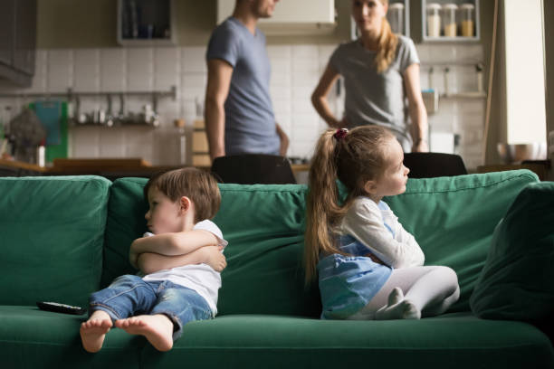 Upset offended brother and sister sitting on couch Upset offended toddler brother and sister sitting separately on couch, sofa with arms crossed, little girl and boy ignoring each other, not talking, puzzled parents discuss situation envy stock pictures, royalty-free photos & images