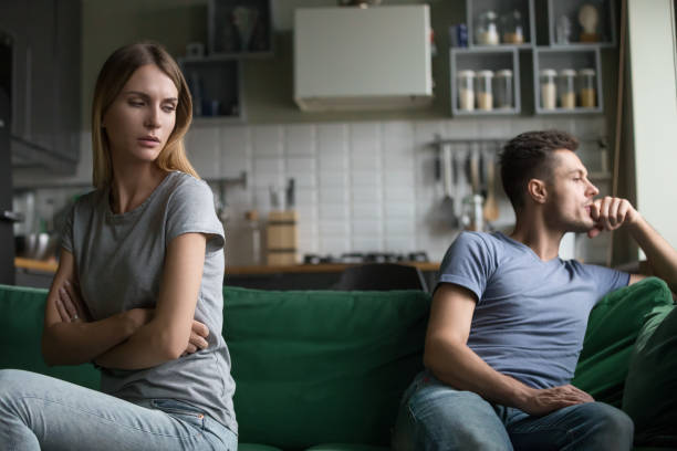 istock Offended upset man and woman sitting separately on couch 1063760012