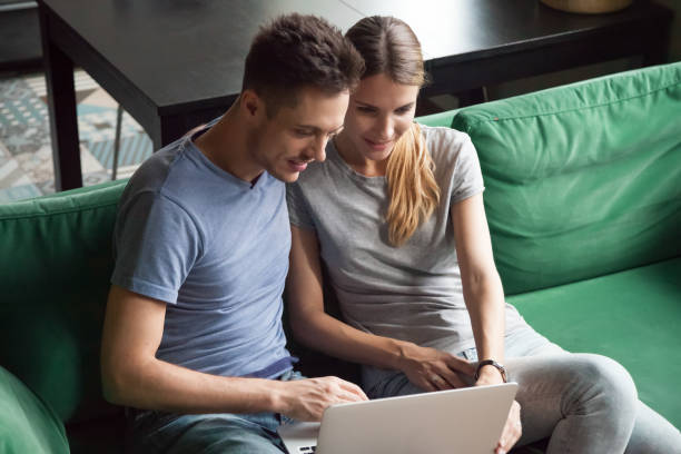 istock Excited man and woman sitting together and using laptop 1063760024