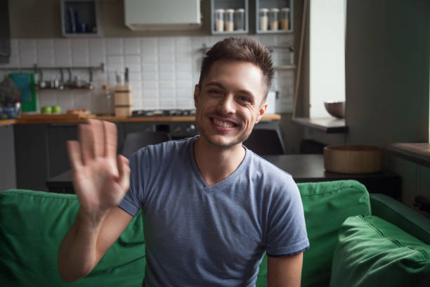 Portrait happy smiling man waving hand, looking at camera
