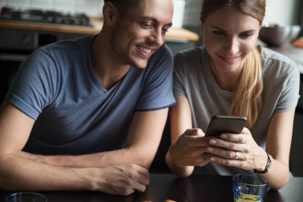 istock Young smiling couple looking at smartphone screen 1063760078