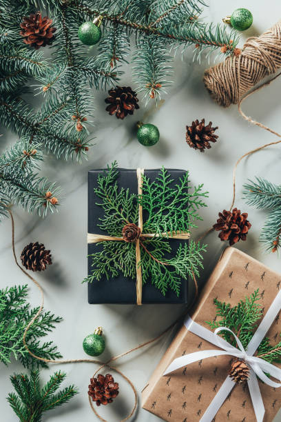 istock top view of gift boxes with christmas balls and pine cones on marble table 1063763330