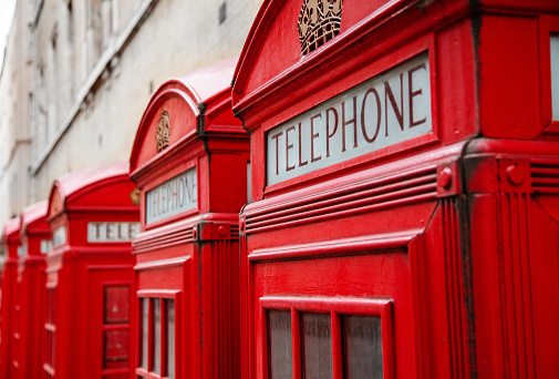 Red telephone booth in London with Big Ben on background.