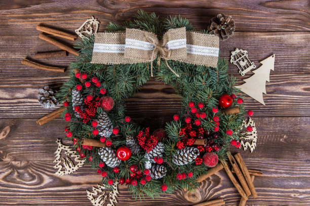 istock Christmas winter frame on dark wooden background. Christmas wreath. red elements 1063765308