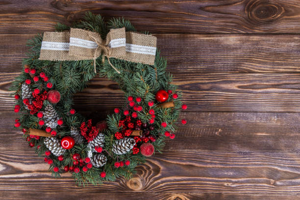 istock Christmas winter frame on dark wooden background. Christmas wreath. red elements 1063765316