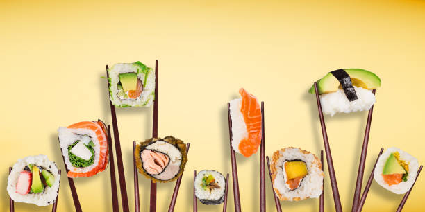 istock Traditional japanese sushi pieces placed between chopsticks, separated on pastel background. 1063767930