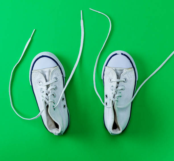 istock pair of white old textile sneakers with untied laces 1063769332