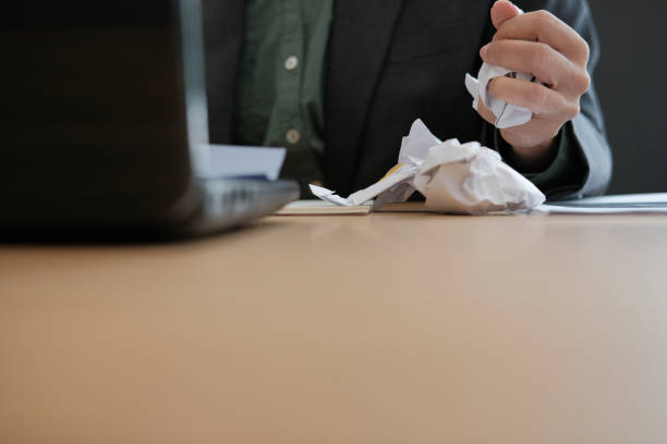 istock stressed upset angry businessman squeezing crumpling paper. 1063770802