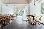白い壁と木の椅子を飾る最小限パン カフェ。快適な居心地の良い、暖かい。