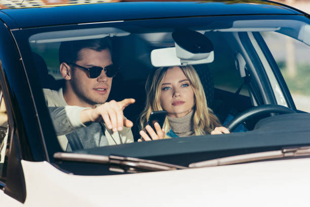 istock man with smartphone showing direction to girlfriend in car 1063779052