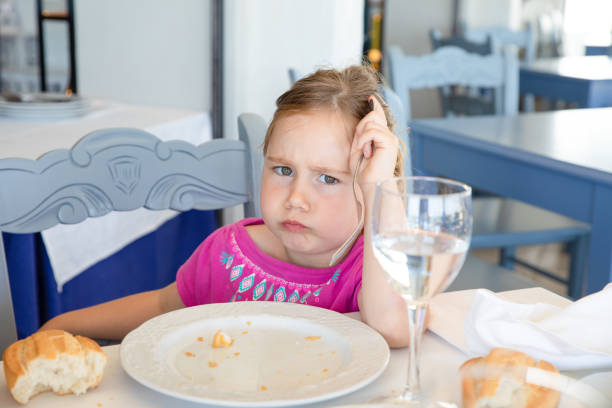 girl eating bread looking at with angry expression in restaurant