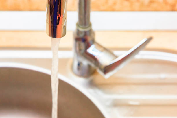 istock Water jet from the faucet in the kitchen sink. 1063788974
