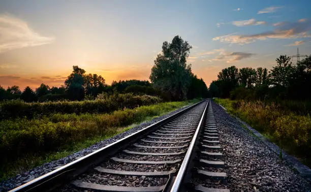 Photo of Railway lines infront of nature and the sunset