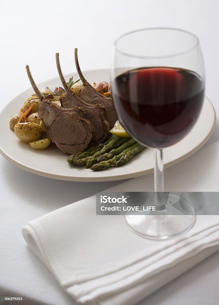 lamb dinner and red wine Elegant red wine and lamb dinner on white table. Alcohol - Drink Stock Photo