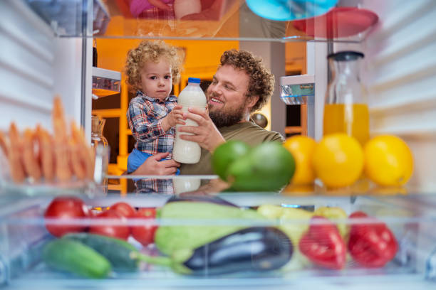 istock Father and son taking milk from fridge in late hours. 1063792904