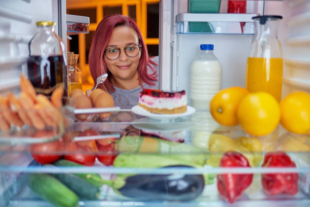 istock Woman standing in front of fridge an looking at cake. 1063793084