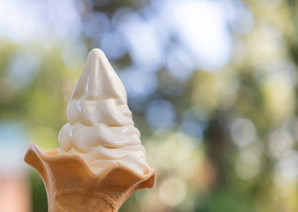 istock soft ice cream cone on green garden background. 1063797078