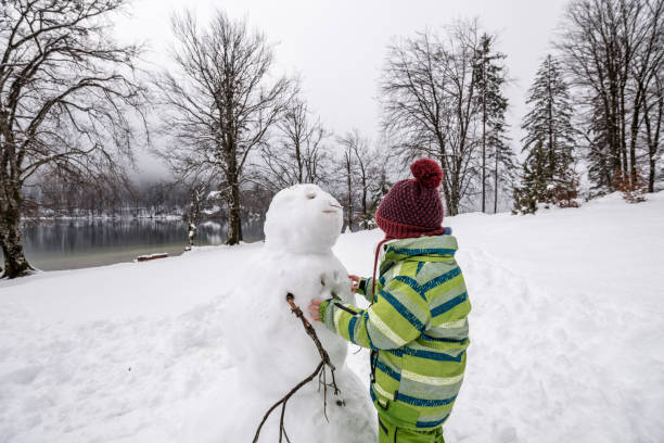 istock Little boy or girl making a snowman 1063797468