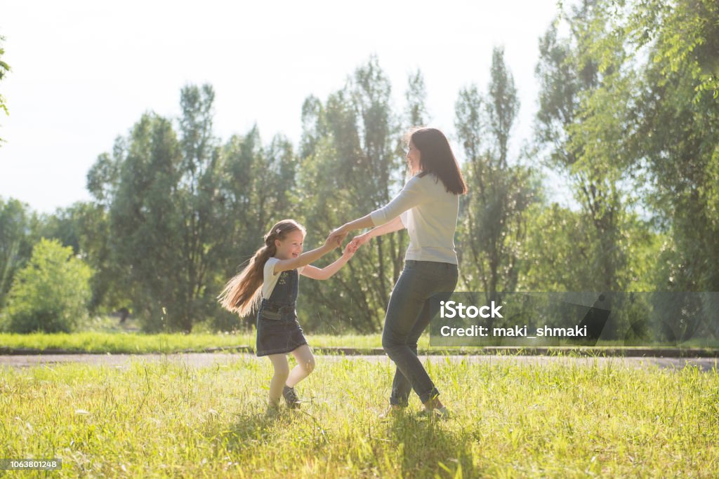ママと娘の手を繋いでいる芝生の上回転 - ダンスのストックフォトや画像を多数ご用意 - ダンス, 円形, 2人 - iStock