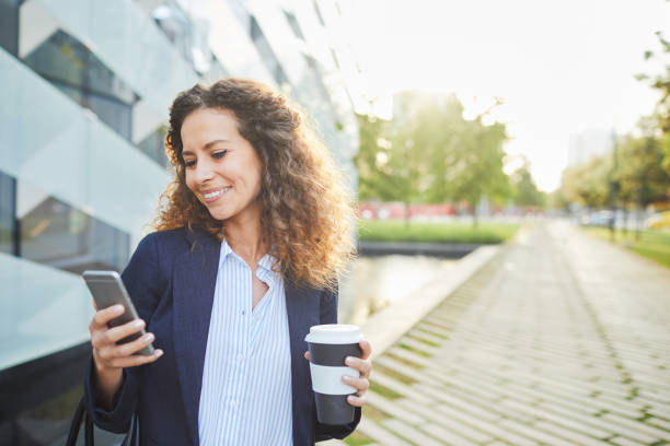 istock Businesswoman texting on her smartphone outside office building. 1063802896
