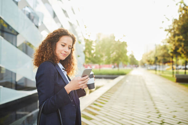 istock Businesswoman texting on her smartphone outside office building. 1063802908