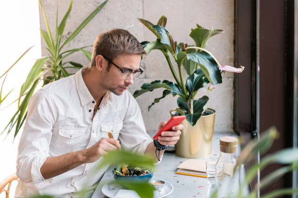 istock Hard-working businessman checking his e-mail on phone having lunch 1063807820
