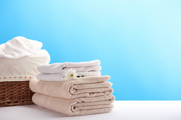 istock laundry basket, towels and chamomile flower on blue 1063810742