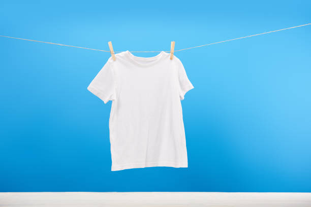 istock clean white t-shirt hanging on clothesline on blue 1063811192