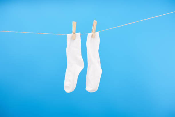 istock clean white socks hanging on clothesline isolated on blue background 1063811286