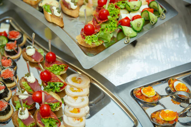 istock Catering table set service various snacks on a table at banquet. Set of cold snacks, canape, beverages, closeup. Side view. 1063813782