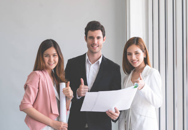 istock Three business people is discussing on Real estate plan looking at camera 1063816978