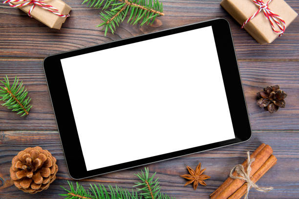 istock Digital tablet mock up with rustic Christmas wooden background decorations for app presentation. top view with copy space 1063817576