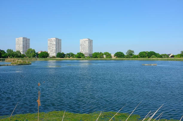 Facing the three tower blocks of the Lincoln Court Estate on the Bethune Road in Stamford Hill from across the East Reservoir in the Woodberry Wetlands Nature Reserve in Woodberry Down, London, England.