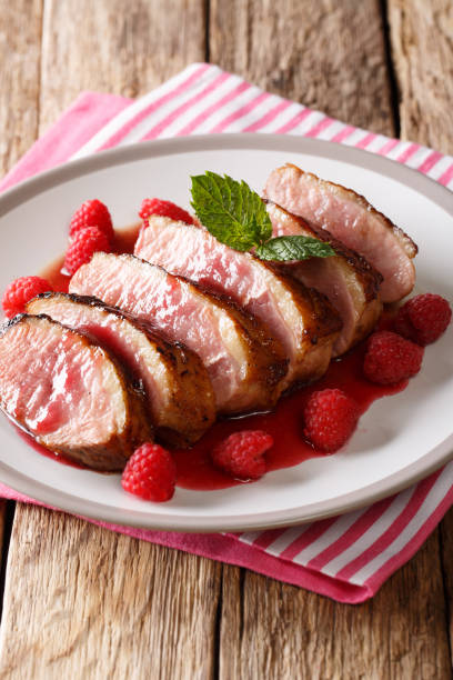 istock Tasty honey duck breast with raspberry sauce and mint on a plate on the table. vertical 1063820662