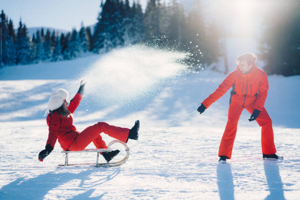 istock Joyful couple sledding on winter holiday 1063820998