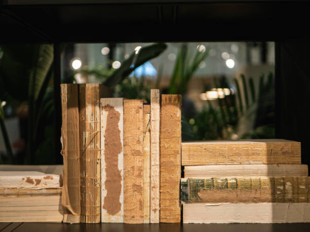 Old, worn out books on a black book shelf