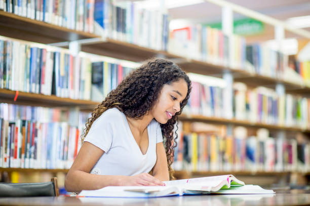 istock Girl reading in the library 1063822128