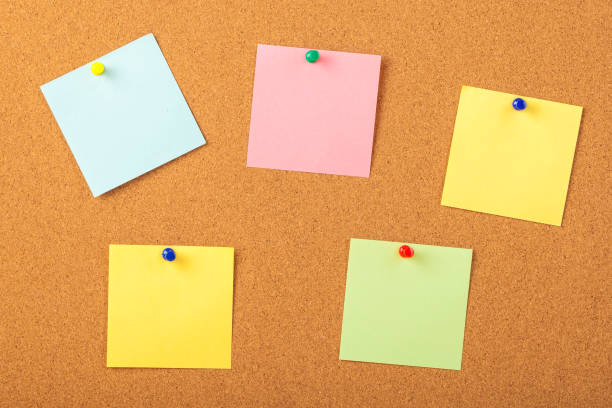 istock colorful papers pined with tacks on brown cork board background 1063824178